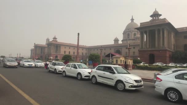 Új-Delhi, India, 2019. november 11., autók állnak a háttérben egy régi épület a fővárosban — Stock videók