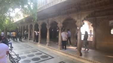 Udaipur, Hindistan - 13 Kasım 2019: Şehir Sarayı turistleri ağaçların gölgesinde duruyor