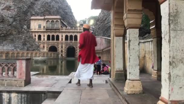 Джайпур, Индия, 4 ноября 2019 года Галта Цзи, туристические прогулки на фоне небольшого храма часть 2 — стоковое видео