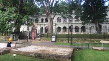 Kandy, Sri Lanka, 20 Kasım 2019, Sri Dalada Maligawa müzenin arka planında yalnız bir turist.