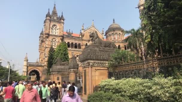 Mumbai, India - November 10, 2019: Chhatrapati Shivaji Terminus tourists walk past the building of the railway station part 2 — Stock Video