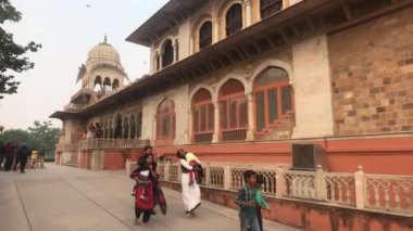 Jaipur, Hindistan - 03 Kasım 2019: Turistler güzel pencerelerle bina boyunca yürüyorlar
