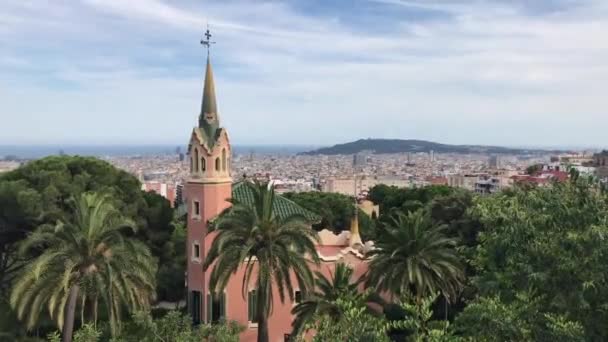 Barcelona, España. Una pequeña torre de reloj junto a una palmera — Vídeos de Stock