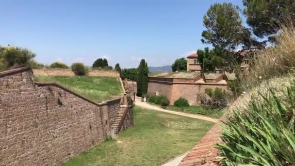 Barcelona, Španělsko. Velká cihlová budova s trávou a hlínou — Stock video