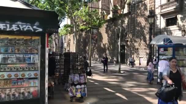 Barcelona, Spanyolország. 2019. június 20.: Egy személy sétál az utcán egy bolt előtt — Stock videók