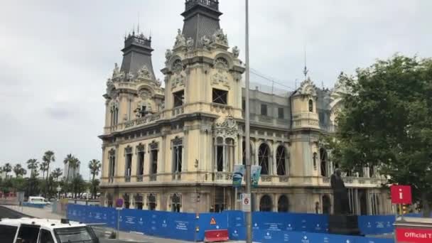 Barcelona, España. Un autobús de dos pisos que conduce por una calle frente a un edificio — Vídeos de Stock