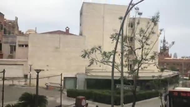 Barcelona, Španělsko. Autobus jedoucí po ulici před budovou — Stock video