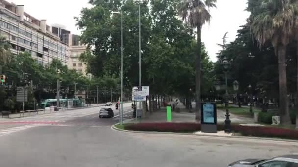 Barcelone, Espagne. Une route vide avec des arbres sur le côté d'un bâtiment — Video