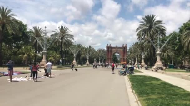 Barcelona, Spanien, 20 juni 2019: En grupp människor som går nerför en gata bredvid ett palmträd — Stockvideo