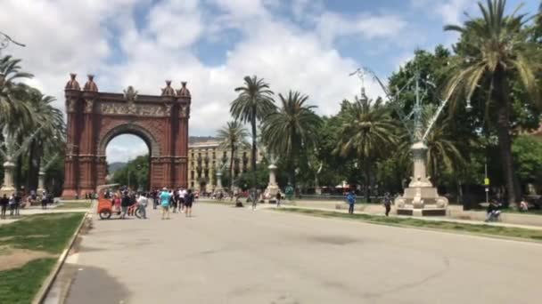 Barcelona, Spanje, 20 juni 2019: Een grote klokkentoren naast een palmboom — Stockvideo