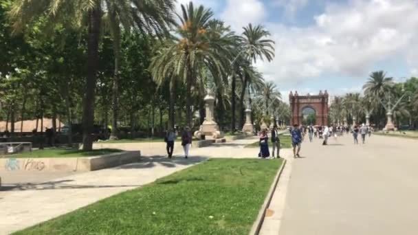 Barcelona, España, 20 de junio de 2019: Un grupo de personas caminando por una calle junto a una palmera — Vídeos de Stock