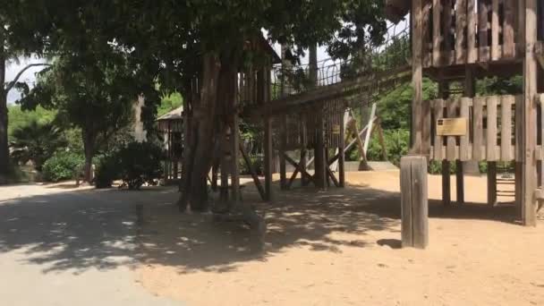 Barcelone, Espagne, Un banc de parc vide à côté d'un bâtiment — Video
