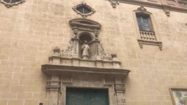 Valencia, İspanya, tuğla duvarın kenarında saati olan büyük taştan bir bina.
