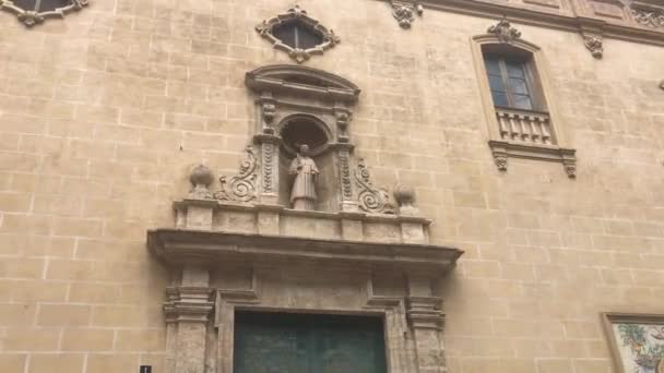 Valencia, Spanien, Ein großes Steingebäude mit einer Uhr an der Seite einer Ziegelmauer — Stockvideo
