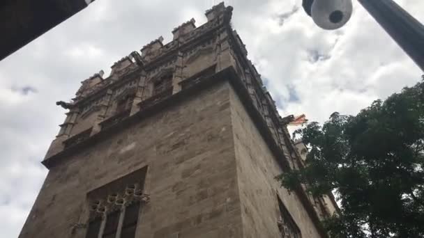 Valencia, España, Una gran torre de ladrillo con un reloj al lado de un edificio — Vídeos de Stock