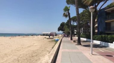Cambrils, İspanya, bir palmiye ağacının önündeki boş kaldırıma yakın çekim.