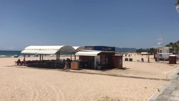 Cambrils, Spanien, 25 juni 2019: Et nærbillede af en sandstrand ved siden af bygningen – Stock-video