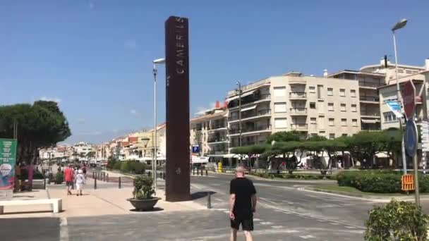 Cambrils, Spanien, 25. Juni 2019: Ein Mann läuft eine Straße neben einem Gebäude entlang — Stockvideo