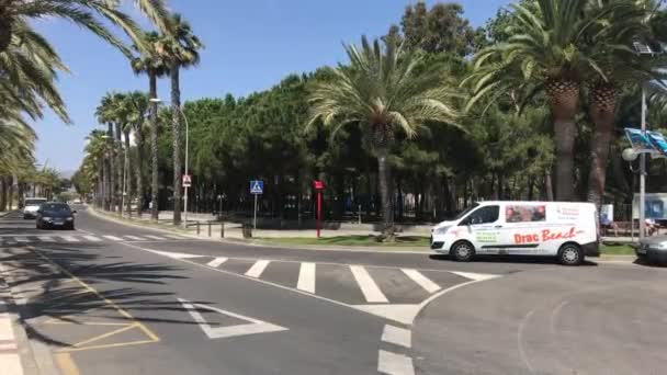 Cambrils, Spanyol, Sebuah mobil mengemudi di jalan di samping pohon palem — Stok Video