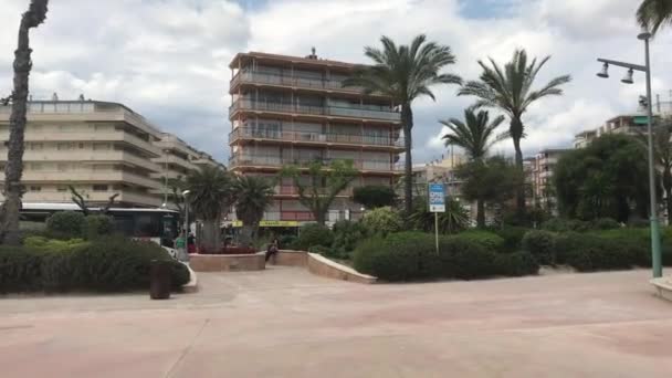 La-Pineda, Espagne, Un grand bâtiment avec des palmiers — Video