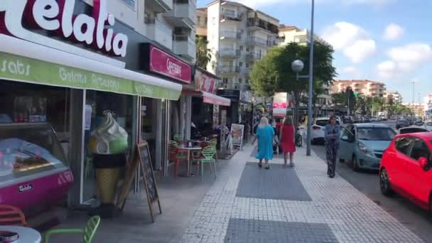La-Pineda, Spanyolország, 2019. június 25.: Egy csoport ember sétál a bolt előtt — Stock videók