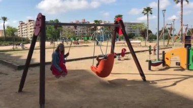 La-Pineda, İspanya, 25 Haziran 2019: kişi parkta salıncakta sallanıyor