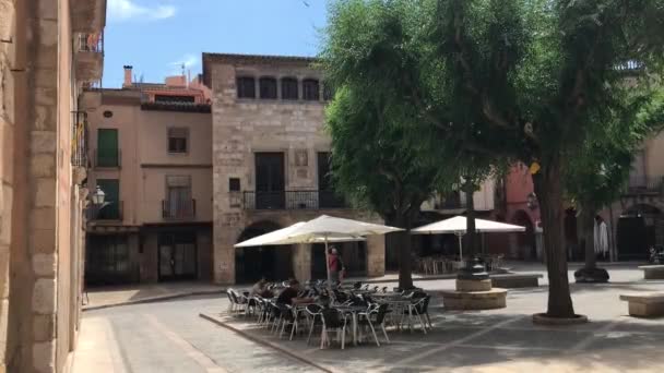 Montblanc, Hiszpania, para ludzi, którzy siedzą po stronie budynku — Wideo stockowe