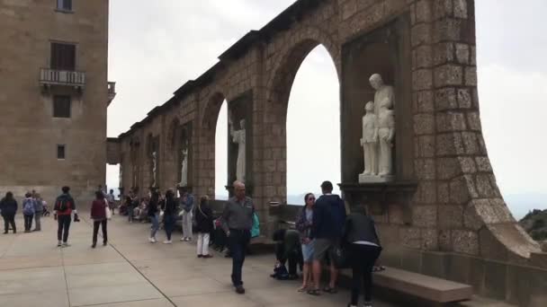 Montserrat, España, 26 de junio de 2019: Un grupo de personas caminando frente a un edificio de piedra — Vídeos de Stock