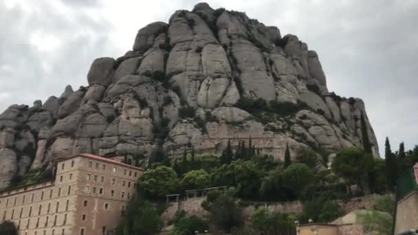 Montserrat, Spanien, Ein großes Steingebäude mit einem Berg im Hintergrund — Stockvideo