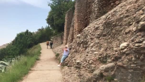 Montserrat, Španělsko, 26. června 2019: Žena kráčí po prašné cestě — Stock video