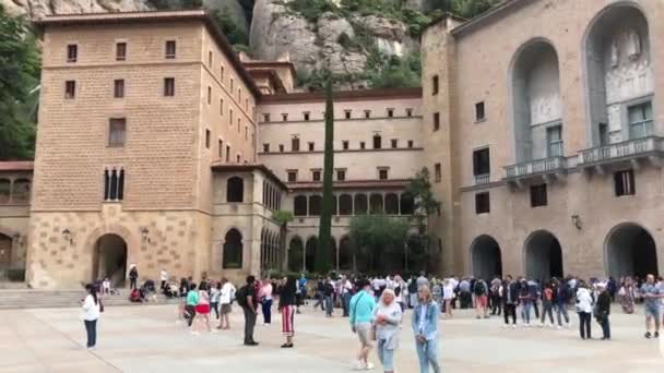 Montserrat, Spanyolország, 2019. június 26.: Emberek egy csoportja sétál egy épület előtt — Stock videók