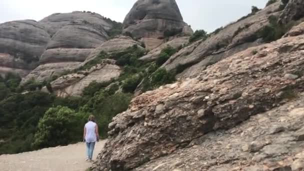 Montserrat, España, 26 de junio de 2019: Una mujer de pie sobre una colina rocosa — Vídeo de stock