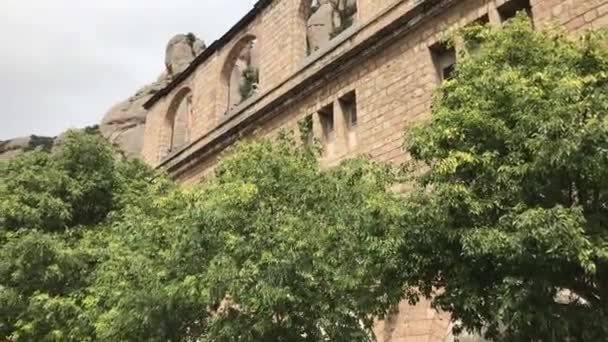 Montserrat, España, Una torre de reloj frente a un edificio de ladrillo — Vídeo de stock