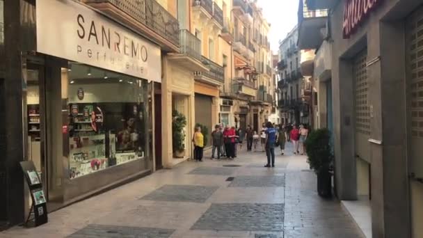 Reus, España, Un grupo de personas caminando por una calle de la ciudad — Vídeos de Stock