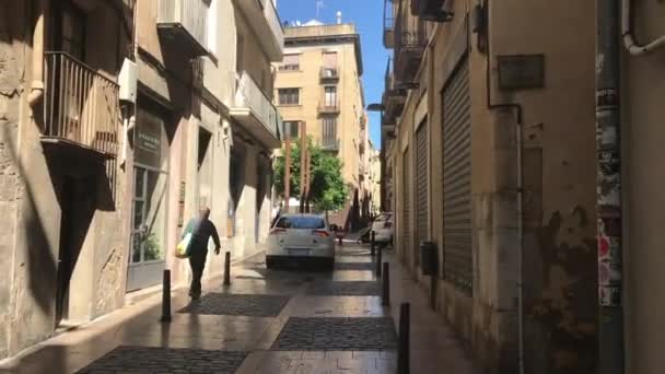 Реус, Испания, 27 июня 2019 г.: Человек, идущий по улице перед зданием — стоковое видео