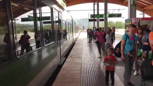 Montserrat, Spanien, 26 juni 2019: En grupp människor som sitter på en tågstation — Stockvideo