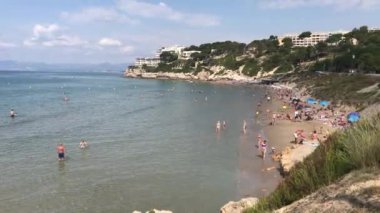 Salou, İspanya, bir grup insan bir su kütlesinin yanında duruyor.