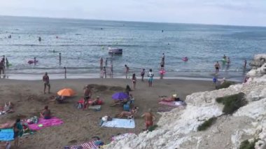 Salou, İspanya, bir grup insan sahilde oturuyor.