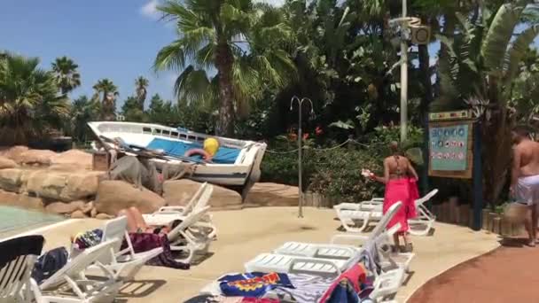 Salou, İspanya, 28 Haziran 2019: Bir grup insan palmiye ağacının önünde bir masada oturuyor — Stok video