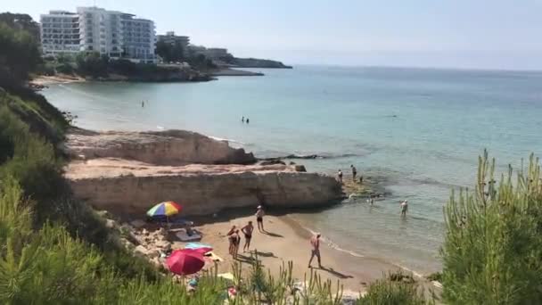 Salou, España, Un grupo de personas de pie junto a un cuerpo de agua — Vídeos de Stock