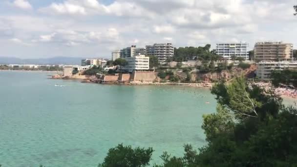 Salou, España, Un gran cuerpo de agua con una ciudad al fondo — Vídeo de stock