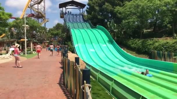 Salou, Espagne, Un groupe de personnes assis autour d'un toboggan — Video