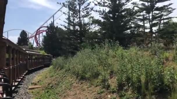 Salou, España, Un tren que desciende por las vías del tren cerca de un bosque — Vídeo de stock