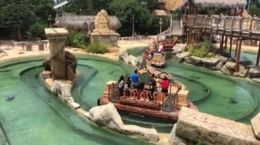 Salou, İspanya, 28 Haziran 2019: Havuzda bir kayanın üzerinde oturan bir grup insan