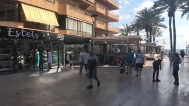 Salou, İspanya, 28 Haziran 2019: Bir grup insan bir binanın önünde yürüyor