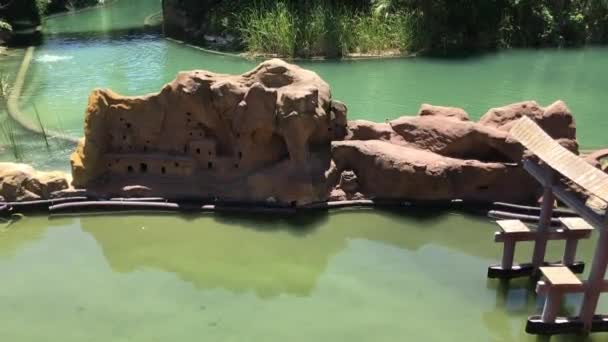Salou, Ισπανία, Ένα άτομο που κάθεται σε ένα βράχο σε μια πισίνα με νερό — Αρχείο Βίντεο