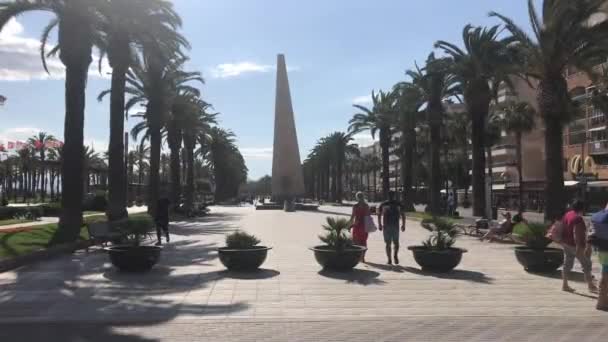 Salou, España, Un grupo de palmeras con un edificio al fondo — Vídeos de Stock