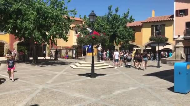 Salou, Spanje, 28 juni 2019: Een groep mensen loopt door een straat naast een gebouw — Stockvideo