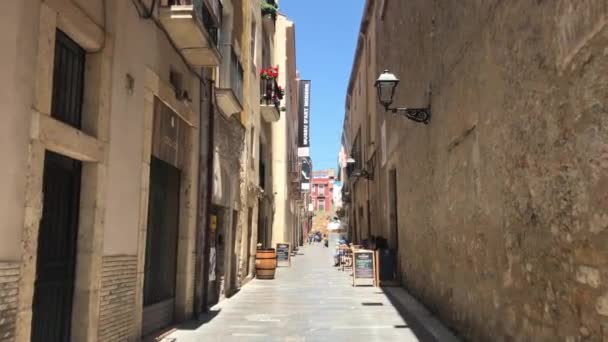 Tarragona, España, Un primer plano de un edificio de piedra que tiene un cartel en una acera — Vídeo de stock