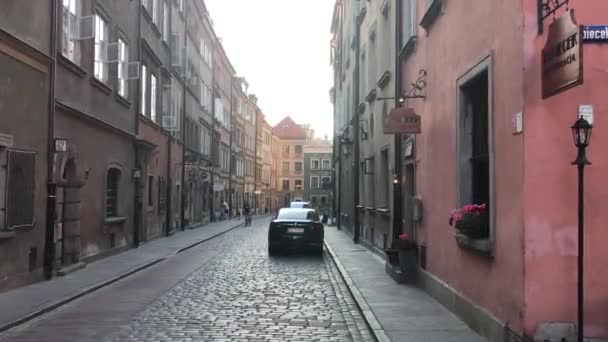 Warszawa, Polonya, dar bir şehir caddesi, bir binanın kenarına park edilmiş arabalar. — Stok video